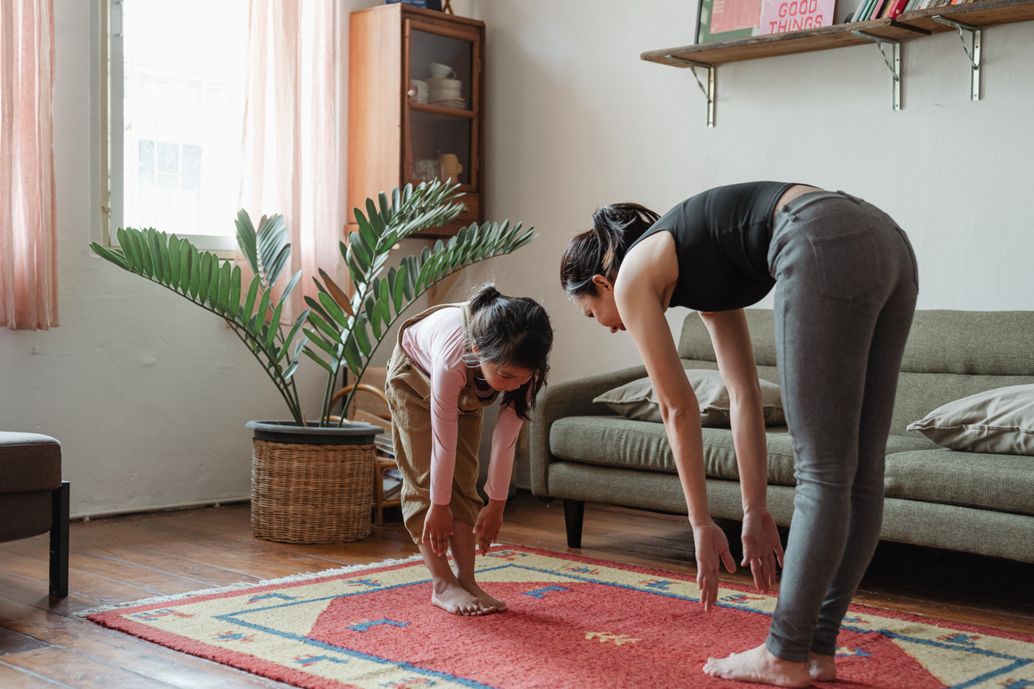 Asian mother and daughter exercising together at home